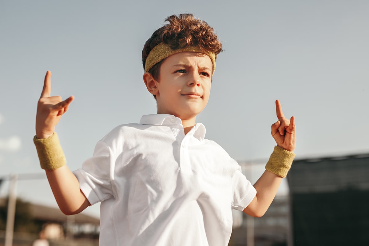 tennis player kid showing horn gesture