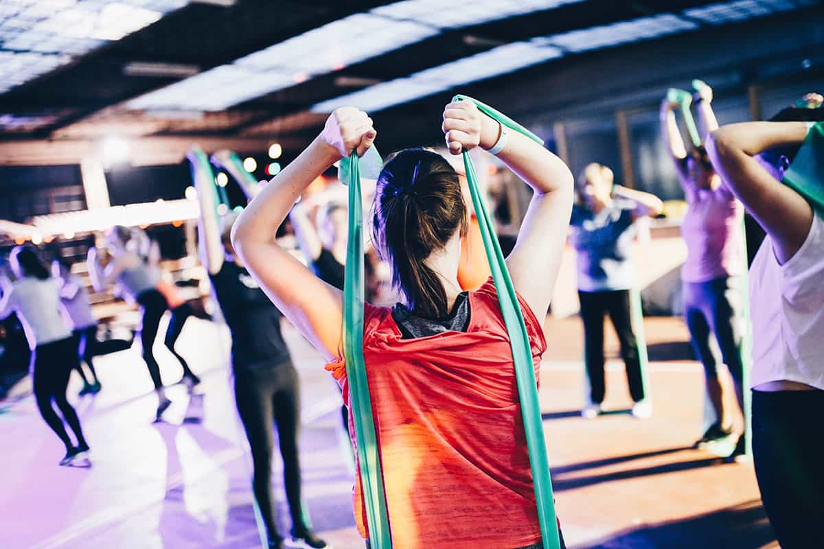 woman using long resistance bands in a gym