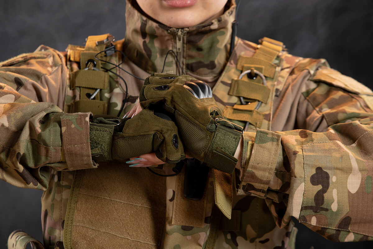 front view female soldier camouflage dark wall