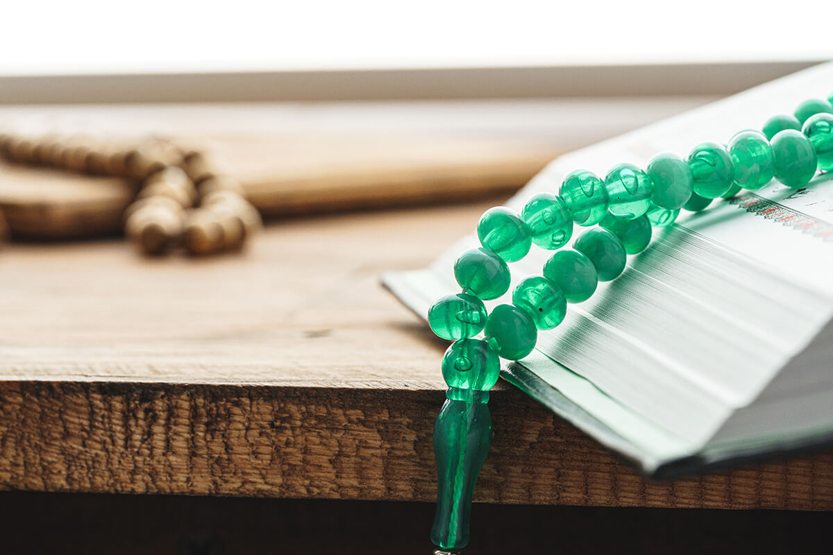 Oriental religious green beads close up on a wooden table