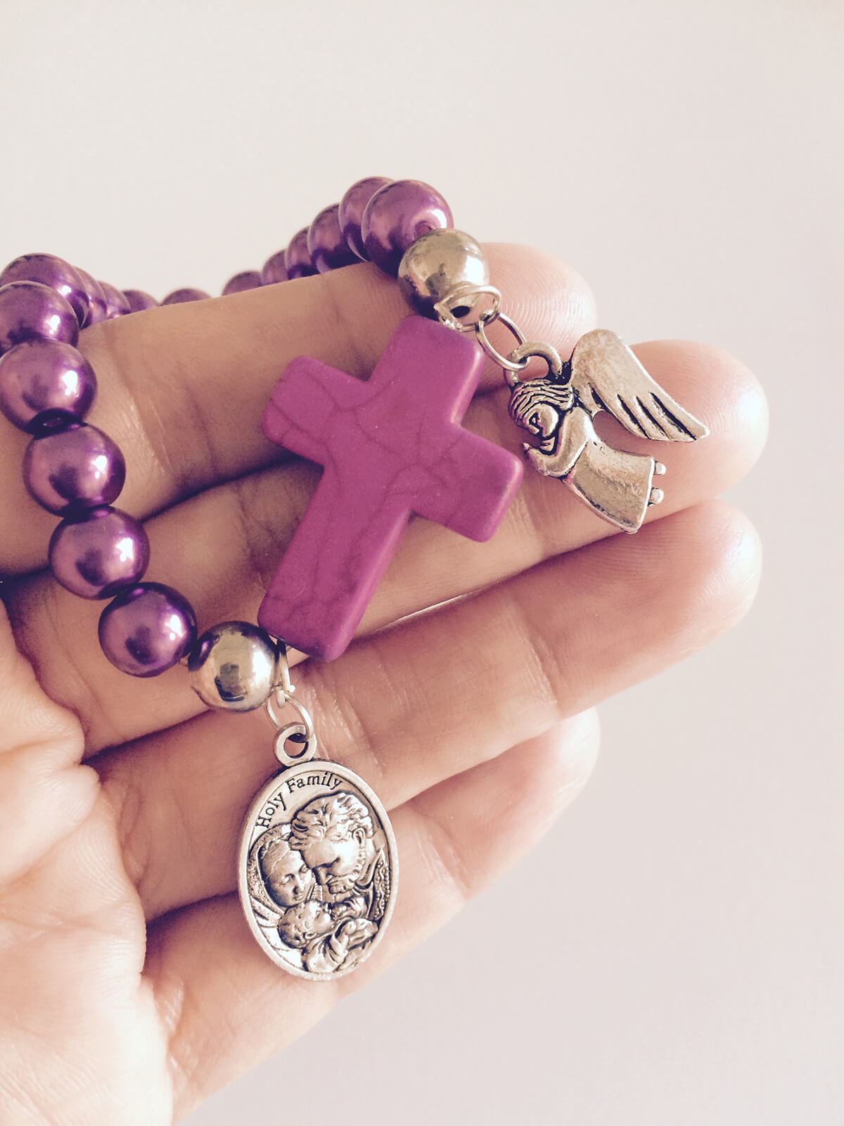 Religion and Faith - Woman praying the Rosary with a small purple rosary in her hand