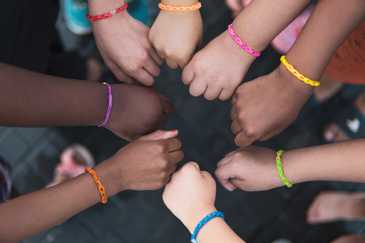 multiethnic-children-hands-together-with-rainbow