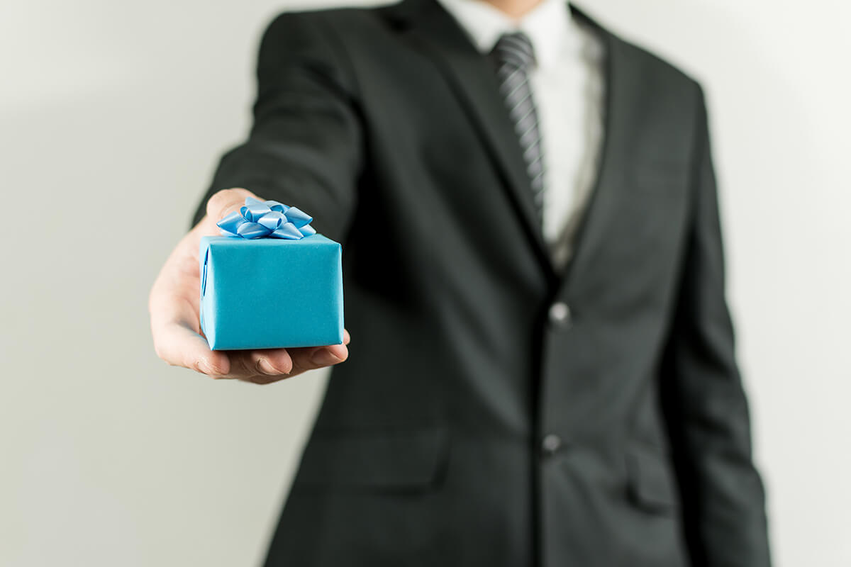 man suit holding blue small present box